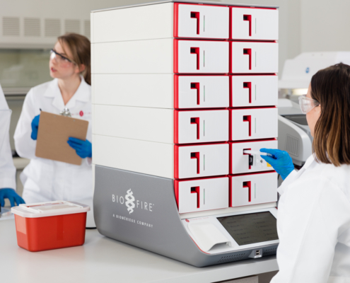Lab technician loading a syndromic testing pouch into the BioFire® Torch System.